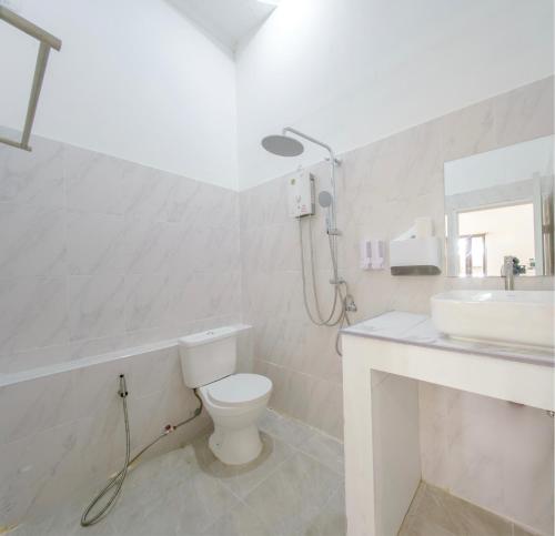 a white bathroom with a toilet and a sink at Three CoCo Villa AoNang Beach in Ao Nang 