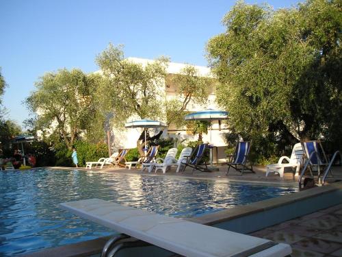 a swimming pool with chairs and umbrellas next to a building at Vieste Residence Gallo Con Piscina in Vieste