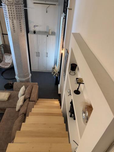 a living room with a couch and a staircase at Apartment Zumbul in Zrenjanin