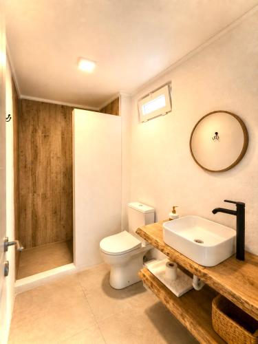 a bathroom with a sink and a toilet and a mirror at Gammi Hayıtbükü in Datca
