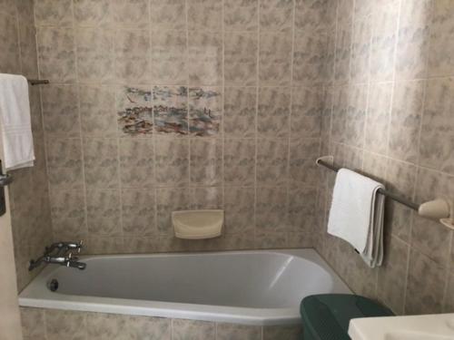 a bathroom with a bath tub and a sink at The Owls Nest in Lakeside