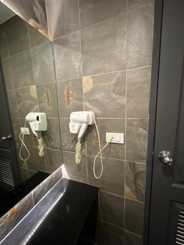 a bathroom with a phone on a tiled wall at Chiangkhong Teak Garden Riverfront Hotel in Chiang Khong