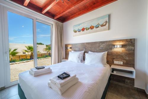 a bedroom with a bed and a large window at Veranda Sul Mare in Gramvousá