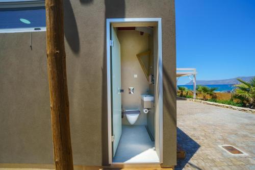 a bathroom with a toilet in the side of a house at Veranda Sul Mare in Gramvousá