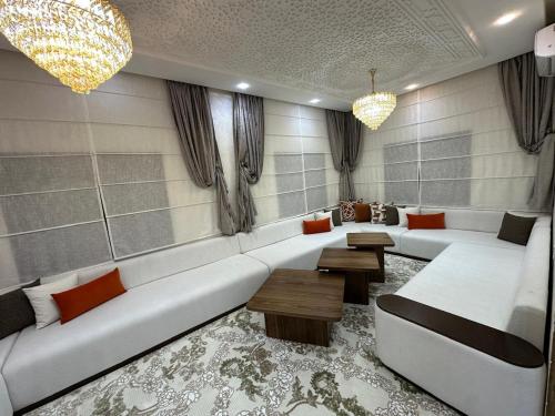 a living room with a large white couch and tables at villa privée ghmat in Marrakesh