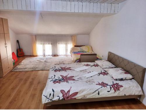 a bedroom with a bed with a floral bedspread at Bus Station Hostel in Peje