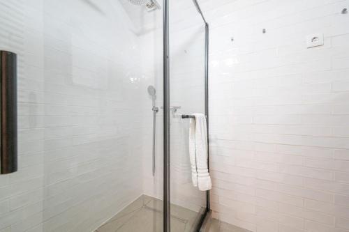 a shower with a glass door in a bathroom at Casa Flora Tiny House in Fuzeta