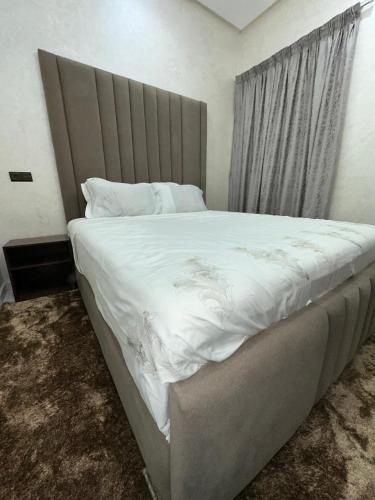 a bedroom with a large bed with white sheets at villa privée ghmat in Marrakesh