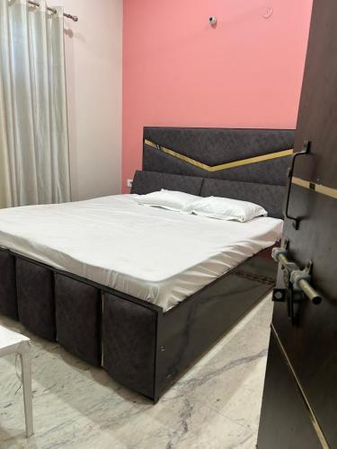 a bed in a room with a pink wall at Prabhukripa Vilas Homestay in Mathura