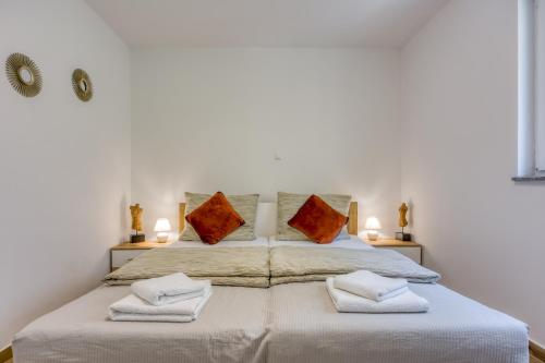 a bedroom with a large bed with two pillows at 2Bfree Apartments in Stinica