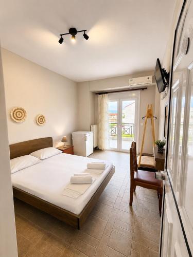 a bedroom with a bed and a desk and a window at Pfaffenhofen in Nea Vrasna