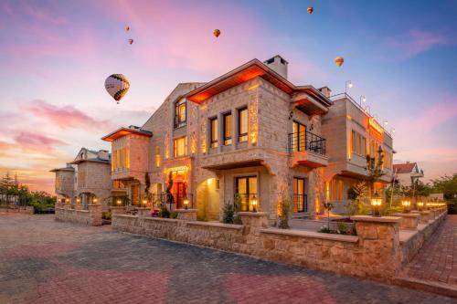 a house with hot balloons in the sky at Cappadocia Golden Elite in Uçhisar