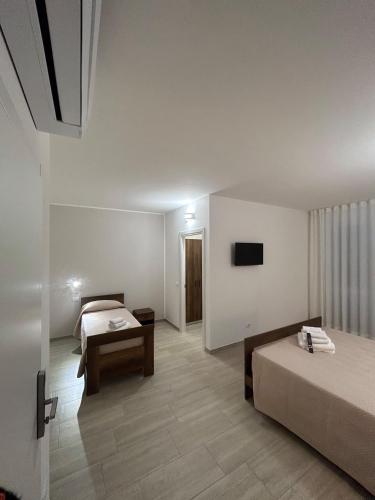 a hotel room with two beds and a table at Foresteria Lombarda Pavia in Pavia