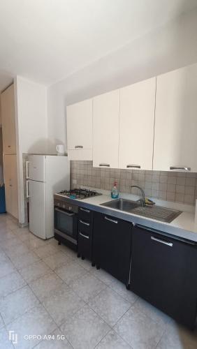 a kitchen with white cabinets and a sink and a stove at Residence Villa Savoia in Marino