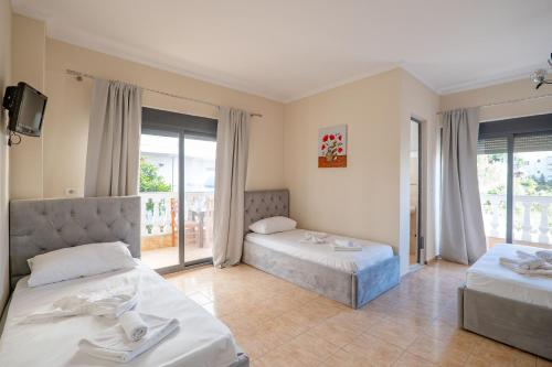 a hotel room with two beds and a balcony at Hotel Primavera in Sarandë