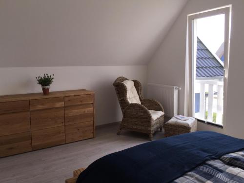 a bedroom with a bed and a dresser and a chair at Strandläufer in Breege