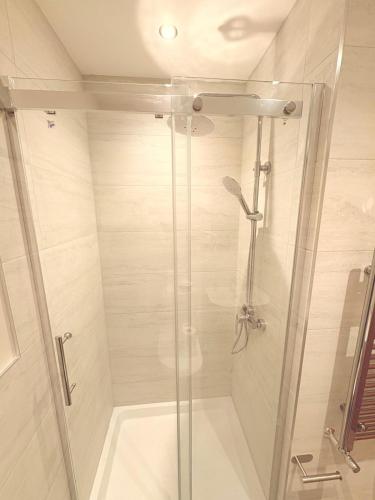 a bathroom with a shower with a glass door at Super Nova Self-Service Hotel in Aberdeen