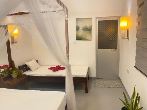 a room with two beds and a canopy bed at Kingly Aroma in Arugam Bay