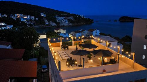 a building with an outdoor patio with umbrellas at night at Apartments and Studios Anicic in Utjeha