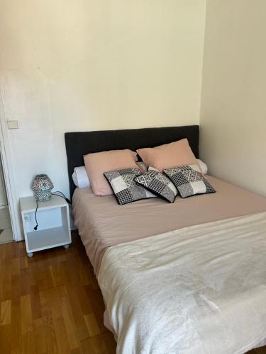 a bed with pillows on it in a room at appartement cosy tout équipe in Épinay-sur-Orge