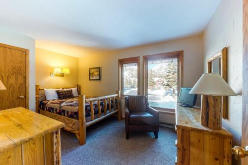 a bedroom with a bed and a chair and a window at Togowotee 108 in Copper Mountain