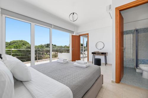 a bedroom with a large bed and a bathroom with a tub at Celestial Luxury Residences in Ixia