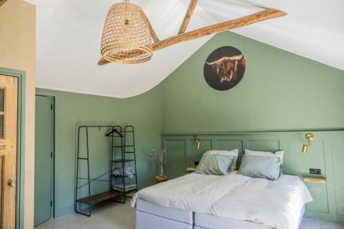 a bedroom with a bed with a green wall at Boerderij 1811 in Harich