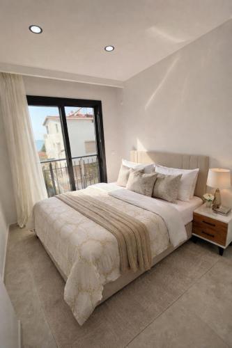 a bedroom with a large bed with a large window at AC Konaklama in Kuşadası