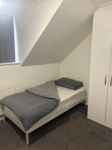 a bed in a white room with a roof at Casa Elisa in Enfield