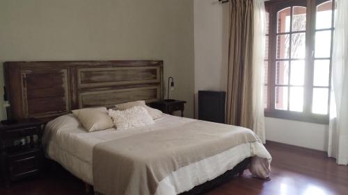 a bedroom with a large bed and a window at Casa Las Clivias in Lobos