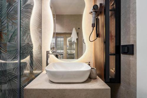 a bathroom with a white sink and a mirror at Una Rooms in Poreč