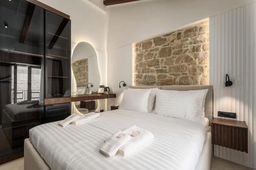 a bedroom with a large white bed with towels on it at Una Rooms in Poreč