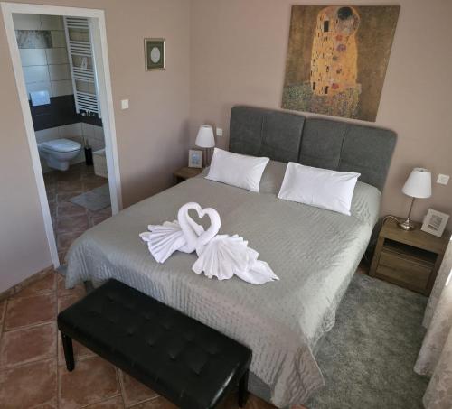 a bedroom with a bed with a white ribbon on it at Sobe - Klet Cinkuš in Hrvatski Leskovac