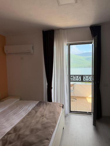 a bedroom with a bed and a view of a balcony at Oruci hotel in Kukës