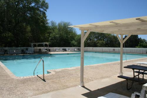 a swimming pool with a table and an umbrella at Medina Lake Camping Resort Cabin 3 in Lakehills