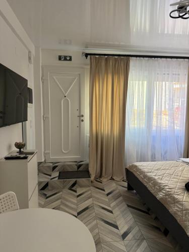 ein Schlafzimmer mit einem Bett und einem großen Fenster in der Unterkunft Studio Lite Ermou#17 in Kateríni