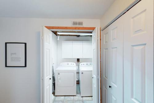 a white laundry room with two washer and dryer at The GingerBreck House in Breckenridge