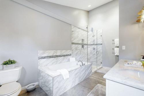 a white bathroom with a tub and a toilet at Lakeview Townhome Unit A5 in Avon