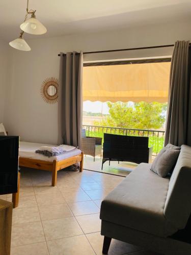 a living room with a couch and a bed and a window at Peaceful Seaside Apartments in Vaia