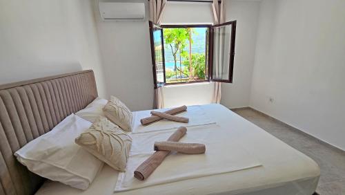 a bed with two logs on it with a window at Villa Sava in Đenovići