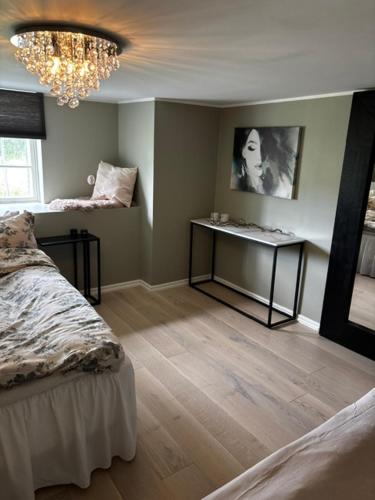 a room with a bed and a table and a chandelier at Roslags Näsby Täby in Täby