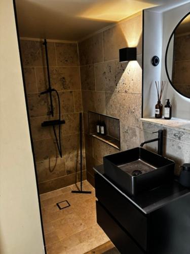a bathroom with a black sink and a shower at Roslags Näsby Täby in Täby
