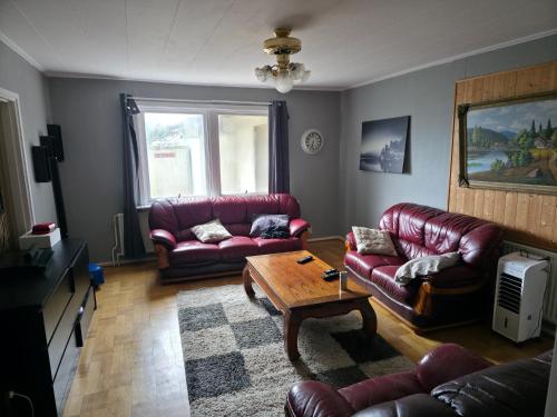 a living room with leather couches and a coffee table at Seaside Koster house in Strömstad