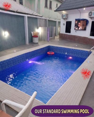 a swimming pool with a bench next to a building at Britney Luxury Apartment in Owerri