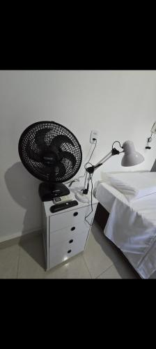 a lamp sitting on a desk next to a bed at Microcasa 6 in Lajeado