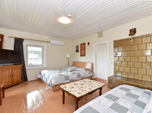 a bedroom with two beds and a flat screen tv at Sodyba Po liepom in Krikštonys