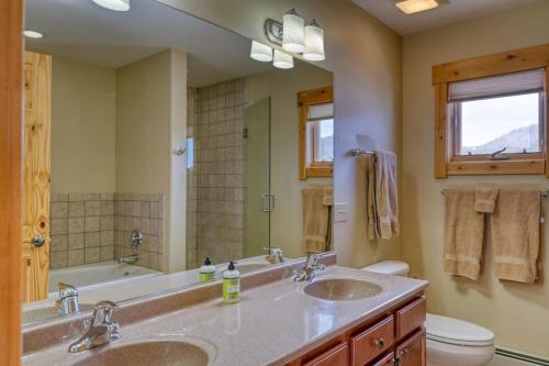 a bathroom with two sinks and a tub and a mirror at Golfers Retreat in South Fork