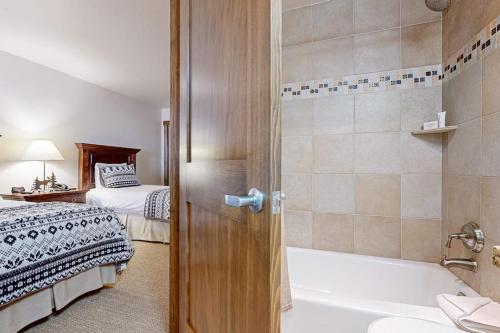 a bathroom with a bed and a bath tub next to a bath tub at Lion Square Lodge North 296 in Vail