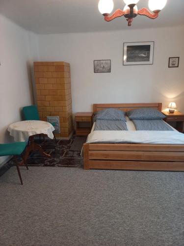 a bedroom with a bed and a table and a chair at Domek u Jadzi in Zwierzyniec