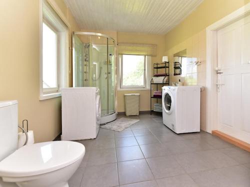 a bathroom with a toilet and a shower and a refrigerator at Sodyba Po liepom in Krikštonys
